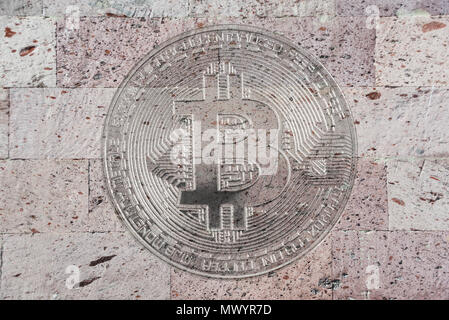 conceptual background ore wallpaper: a wall of natural pink tuff with a symbolic image of bitcoin, crypto currency, new digital money in cyber world Stock Photo