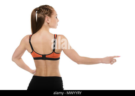 back view of sporty young woman pointing away with finger isolated on white Stock Photo