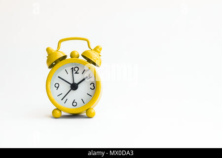small analogue yellow golden clock in isolated white background. Stock Photo