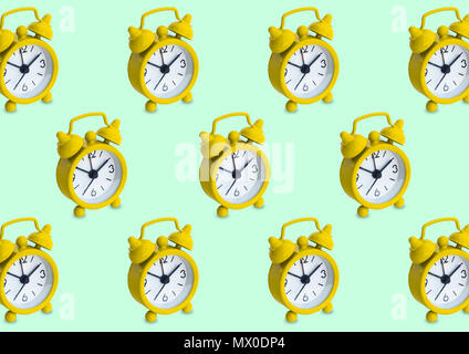 Seamless pattern made of golden analogue clocks in isolated green pastel background. Stock Photo