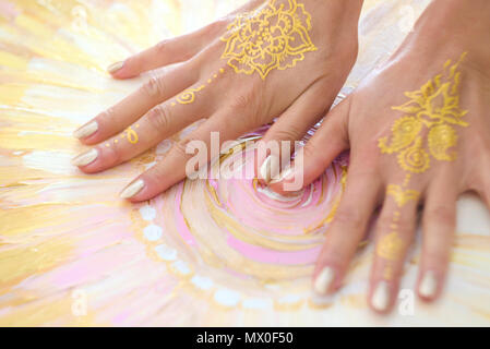 Two open empty Mehndi hands with palms down isolated on painted background. Gold pattern. Art therapy. Stock Photo