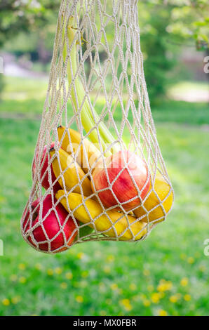 Trendy string bag with fruits. Shopping bag. Trendy closeup for lifestyle design. Fresh fruit. Cloth bag. Ecological bag - an alternative to polyethyl Stock Photo