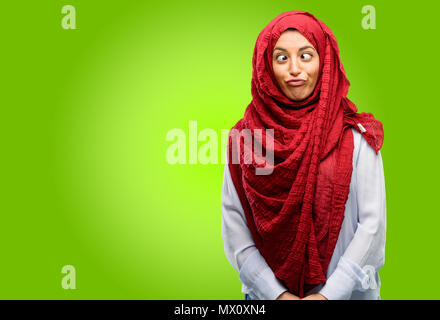 Young arab woman wearing hijab making funny face fooling Stock Photo