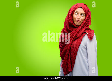 Young arab woman wearing hijab making funny face fooling Stock Photo