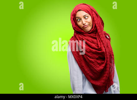 Young arab woman wearing hijab making funny face fooling Stock Photo