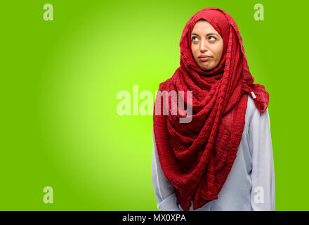 Young arab woman wearing hijab making funny face fooling Stock Photo