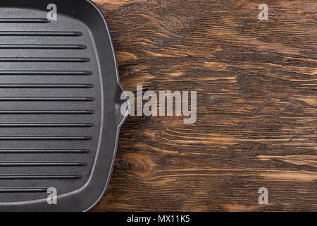 empty grill pan on a wooden background, space for writing recipe Stock Photo