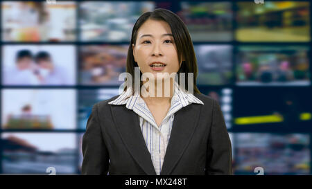 Asian American anchorwoman in TV studio Stock Photo