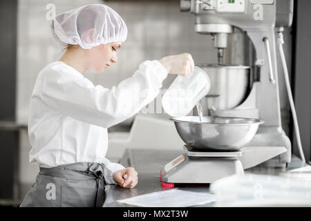 Confectioner working at the bakery manufacturing Stock Photo