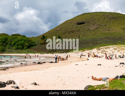 People on Anakena sandy curved bay beach, Easter Island, Rapa Nui, Chile, with storm clouds Stock Photo