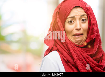 Young arab woman wearing hijab feeling disgusted with tongue out Stock Photo