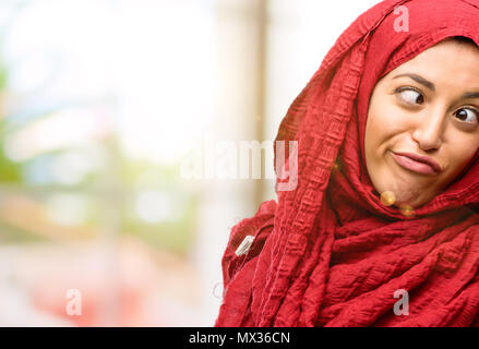 Young arab woman wearing hijab making funny face fooling Stock Photo