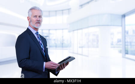 Portrait of senior businessman using tablet in front of his modern office Stock Photo