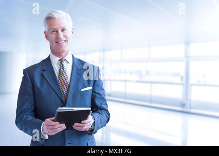 Portrait of senior businessman using tablet in front of his modern office Stock Photo
