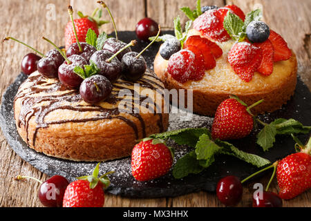 Summer fruit cakes with chocolate, mint, strawberries, cherries and blueberries close-up on a slate board. horizontal Stock Photo