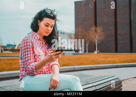 A disgusted woman looks at the phone. The surprised girl reads something strange, puzzling. The woman reads something that upset her. Stock Photo