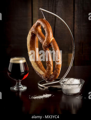 Salted pretzel with some on the table with a glass of beer Stock Photo