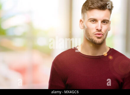 Handsome young man expressing love, blows kiss at camera, flirting Stock Photo