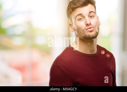 Handsome young man expressing love, blows kiss at camera, flirting Stock Photo