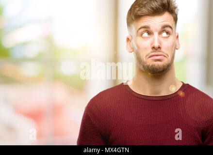 Handsome young man having skeptical and dissatisfied look expressing Distrust, skepticism and doubt Stock Photo
