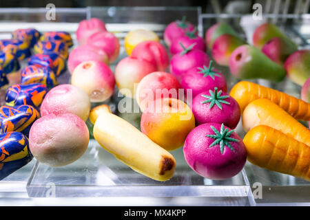 Macro closeup of creative colorful shapes from candy shaped vegetables, tomatoes, carrots on display in confectionery bakery store shop Stock Photo
