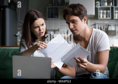 Frustrated wife shocked by bad news reading letter with husband  Stock Photo