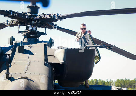 Chief Warrant Officer 2 Sexton assigned to 1st Attack Reconnaissance Battalion, 82nd Combat Aviation Brigade performs preflight checks on an AH-64 Apache helicopter before flight in support of a joint Combined Arms Live Fire Exercise on Fort Bragg, N.C., May 3. Stock Photo