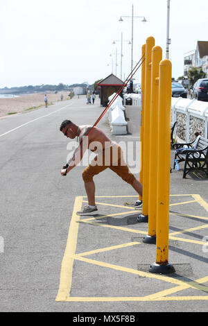 A man pictured using outdoor exercise equipment on the beach in Bognor Regis, West Sussex, UK. Stock Photo