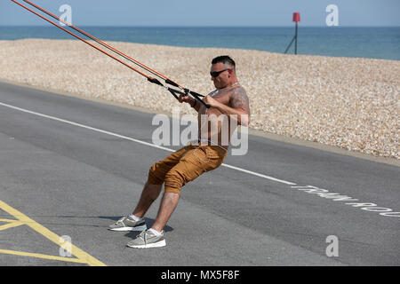 A man pictured using outdoor exercise equipment on the beach in Bognor Regis, West Sussex, UK. Stock Photo