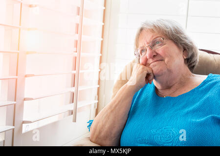 Content Senior Woman Gazing Out of Her Window. Stock Photo