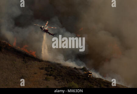 Aliso Viejo, California, USA. 2nd June, 2018. Helicopter drops water as wildfire flames burning vegetation Saturday afternoon, June 2, 2018, in Aliso and Wood Canyons Wilderness Park in Laguna Niguel. The fire is being fought by 200 firefighters, fixed wing aircraft and helicopters, near Laguna beach and the Pacific coast. Crews battle 250-acre brush fire in Wood Canyon, as thousands of evacuations underway in Laguna Beach, Aliso Viejo. Credit: Ruaridh Stewart/ZUMA Wire/Alamy Live News Stock Photo