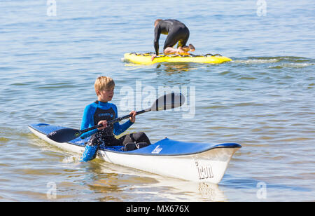 Branksome Chine, Poole, Dorset, UK. 3rd June 2018. UK weather: a lovely warm sunny start to the day, as visitors head to the seaside. Boy enjoying being on the sea in a surf ski. Credit: Carolyn Jenkins/Alamy Live News Stock Photo