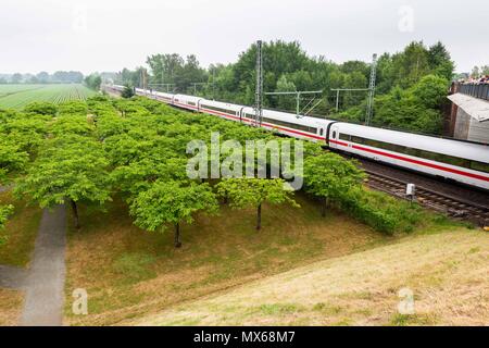 Eschede, Germany. 03 May 2018, Germany, Eschede: An ICE train passing by the memorial event for the victims of the train accident in Eschede for the 20th anniversary of the accident. The ICE 'Wilhelm Conrad Roentgen' derailed on the 3 June 1998 at tempo 200 and drove into a highway bridge. 101 people died. Photo: Philipp von Ditfurth/dpa Stock Photo