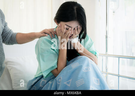 Asian young woman patient receiving bad news, Woman patient is desperate and crying. Her Mother support and comforting her patient with sympathy. Stock Photo