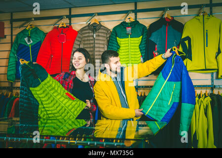 Young couple buys a sports windbreaker in a store Stock Photo