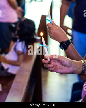 Hands Holding Candles Inside A Catholic Church. Concept Of Religious 