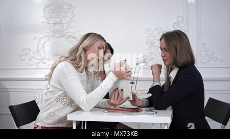 Three beautiful creative business woman working with documents and watching something on tablet in office Professional shot on BMCC RAW with high dyna Stock Photo
