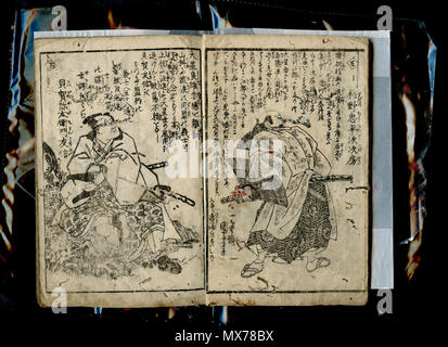 . English: E-hon dipicting the characters from the Chushingura (fictional interpretation of the non-fictional tale of the 47 ronin, involving the use of pseudonyms & theatrical plot conventions, etc.). Title not identified, author not identified, illustrated by Utagawa Kuniyoshi, late Edo period (circa 1850's). Scanset of 1 volume (unknown if book is part of a series, or a single volume publication). Right & left pages each show a samurai warrior (male), with swords, but in casual dress. Images have been hand-coloured in an atypical-style, presumably by a previous owner of the volume. Right-to Stock Photo