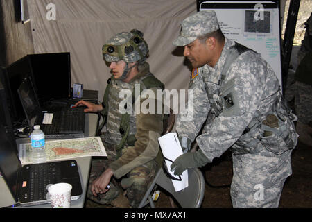 Capt. Anselmo Lizama, a digital master gunner for 1st Brigade, Great Lakes Training Division, 75th Training Command, instructs a Soldier in the 419th Combat Services Support Battalion on the Mission Command Work Station. Lizama, who hails from Guam, serves on the GLTD observer controller/trainer team assigned to the 419th CSSB during WAREX 86-17-02. The ongoing WAREX is being conducted at Ft. McCoy, Wisconsin. The 419th CSSB is headquartered in Tustin, California. Stock Photo