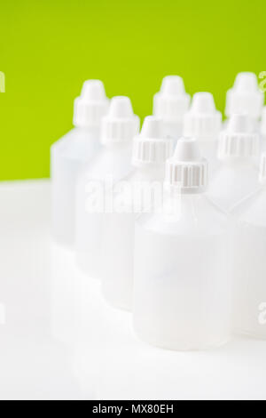 white translucent bottles used in homeopathy on green and blurred bottles background Stock Photo