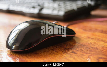 Black computer laser mouse on table with keyboard Stock Photo