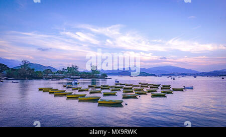 The recreational and fishing boats are parked on the lake at sunset Stock Photo