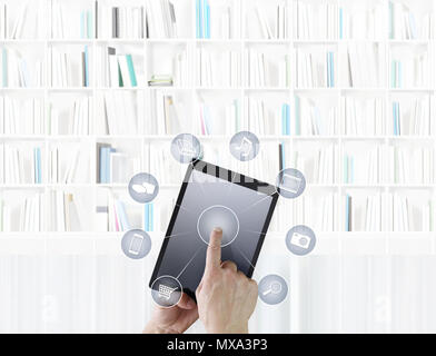 hand touching digital tablet with icons isolated on library background Stock Photo