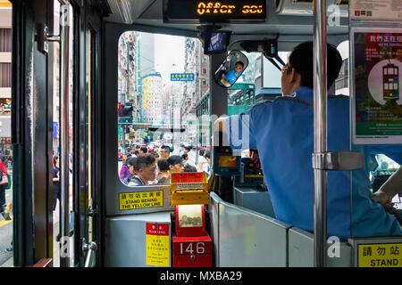 Tram driver waiting for pedestrians at road junction, Hong Kong, SAR, China Stock Photo