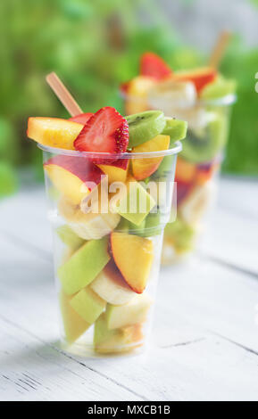 Fruit salad in plastic cups takeaway. Sliced organic fruits and berries, healthy snack to go, copy space. Stock Photo