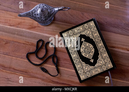 Holy islamic book Quran on the wodden background with a rosary and Egypt aladdin lamp -Ramadan kareem/Eid al fitr Concept. Stock Photo