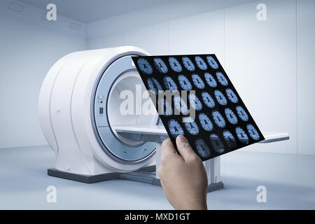 Hand holding x-ray film with 3d rendering mri scan machine or magnetic resonance imaging scan device Stock Photo