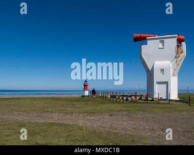 Small Winkie lighthouse on shingle beach with foghorn decommissioned 2005 Point of Ayre Isle of Man on lovely May day with blue sky Stock Photo