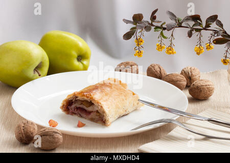 Slice of fresh baked homemade apple strudel with raisins, walnut and sugar powder and nuts Stock Photo