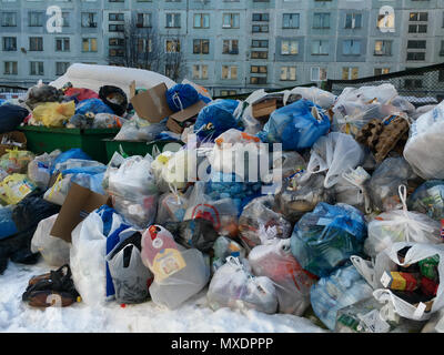 Gadjievo, Russia - April 8, 2018: Overflowing garbage containers in a yard of an apartment house Stock Photo